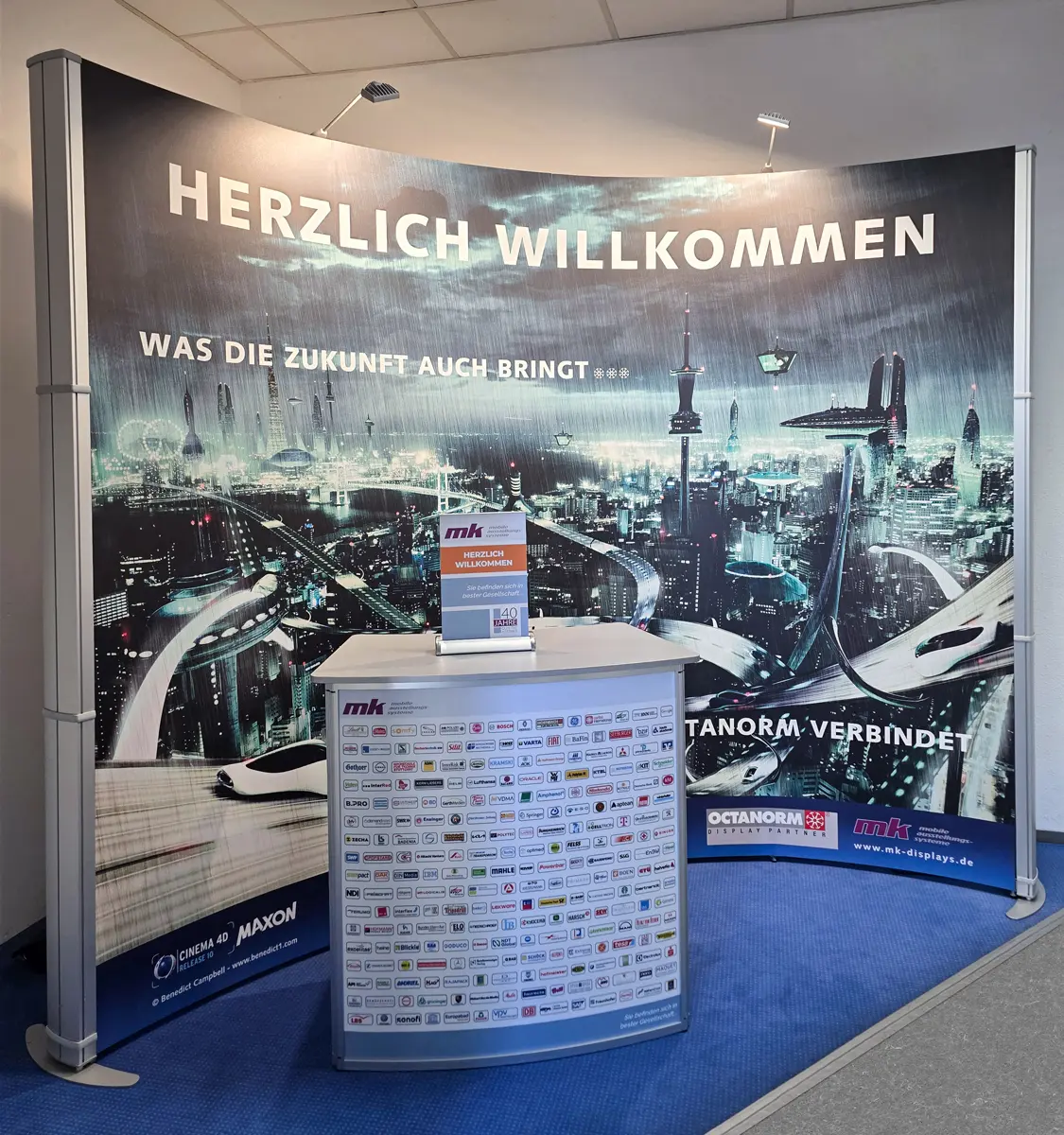 Moderner Messestand mit futuristischer Stadtgrafik und Willkommensgruß.